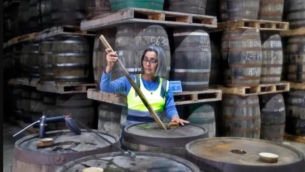 Fotografía de una especialista en la calidad del ron inspeccionando barriles de añejamiento, en la destilería cubano-francesa Havana Club en San José (Cuba) EFE Ernesto Mastrascusa