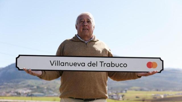 El alcalde de Villanueva del Trabuco, Juan Luis Gallardo, con una señal con el logo de Mastercard.