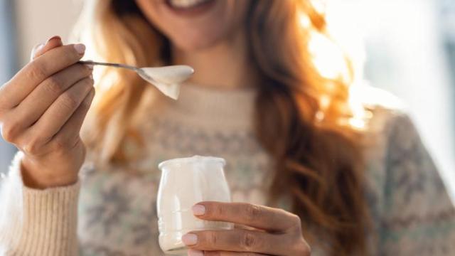 Mujer comiendo un yogur.