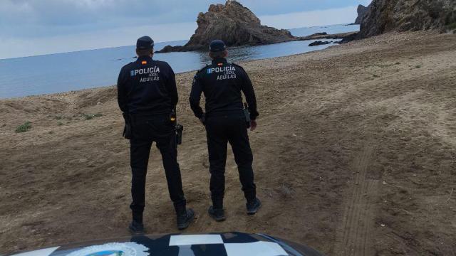 Andrés y Germán, agentes de la Policía Local de Águilas, posan en la playa de El Rafal, donde rescataron a tres inmigrantes que estaban ahogándose.