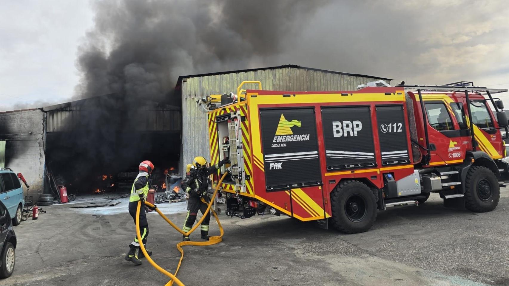 Los bomberos trabajan para extinguir el incendio de una nave industrial de Retuerta del Bullaque