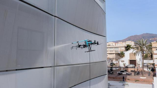 Imagen de un dron limpiando la fachada de El Mirador del Carmen, en Estepona.