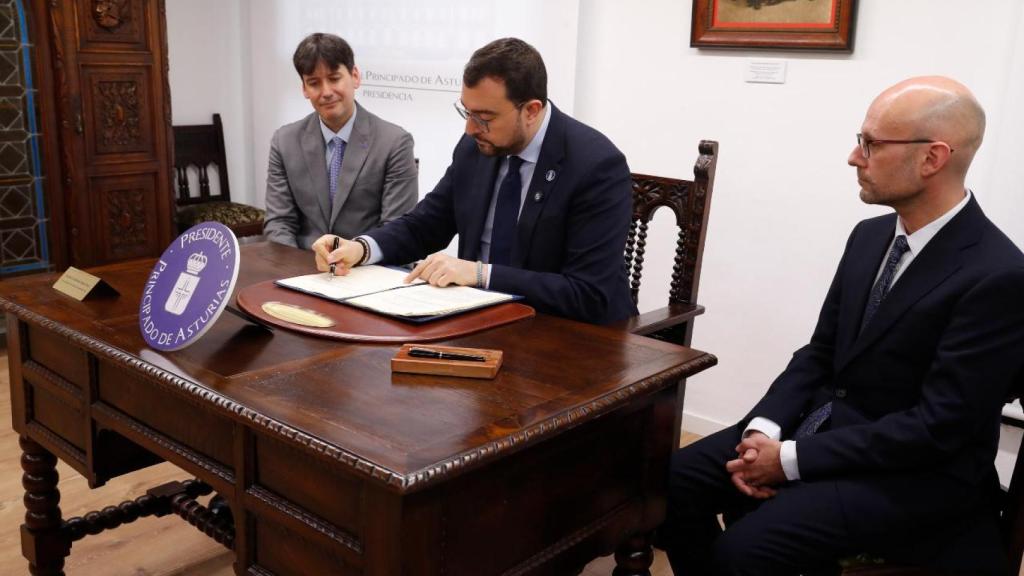 El presidente asturiano, Adrián Barbón, firma la ley de ciencia, con Borja Sánchez, consejero de Ciencia, a su derecha.