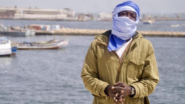 El hombre posa para la cámara de EL ESPAÑOL en una de las playas donde, cuando cae la noche, grupos de migrantes se suben clandestinamente a cayucos para iniciar su travesía hasta Canarias.