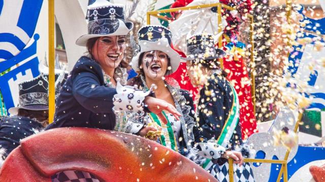 Participantes del desfile de carnaval de Algeciras lanzan confeti.