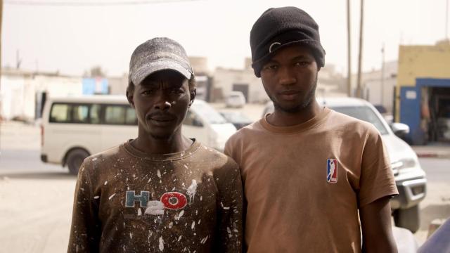 Los dos jóvenes posan para la cámara de EL ESPAÑOL desde uno de los barrios del interior de Nuadibú, donde comparten habitación con otras diez personas.