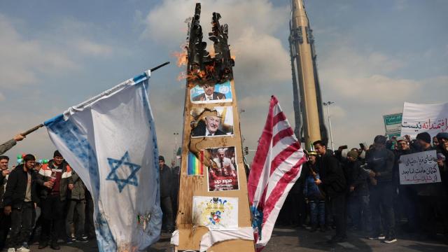 Los iraníes queman banderas israelíes y estadounidenses durante el 46 aniversario de la Revolución Islámica en Teherán.