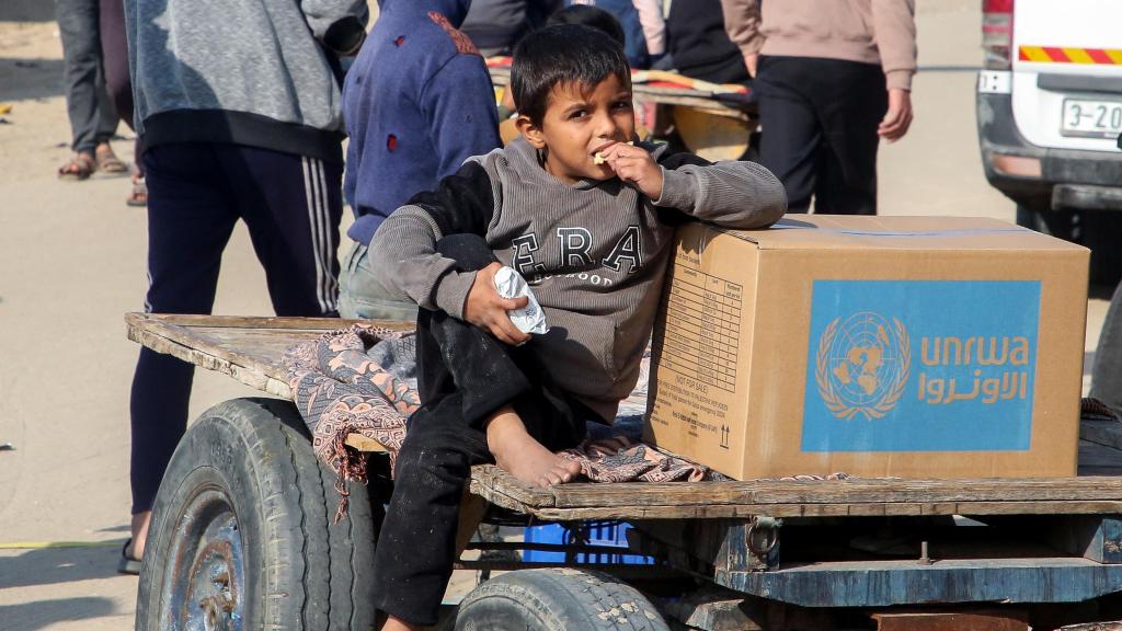 Un niño con un paquete de ayuda de la UNRWA en Jan Yunis.