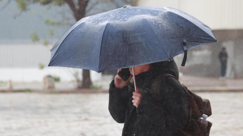 Una persona se protege de la lluvia con un paraguas.