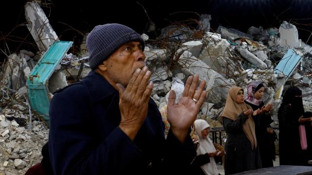 Un grupo de palestinos rezan entre ruinas durante el Ramadán, en Rafah.