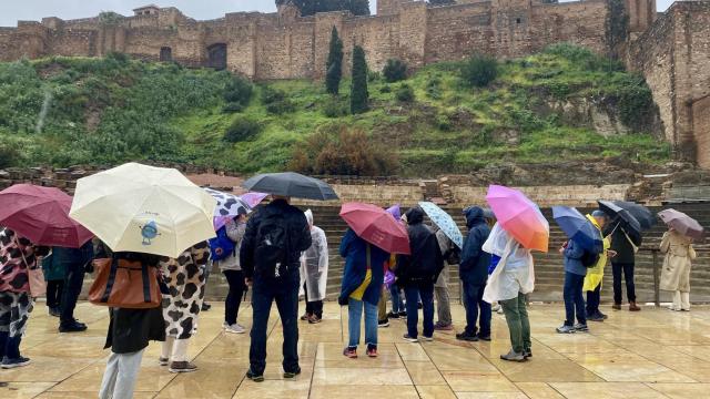 Un grupo de personas caminan protegidas de la lluvia en Málaga.