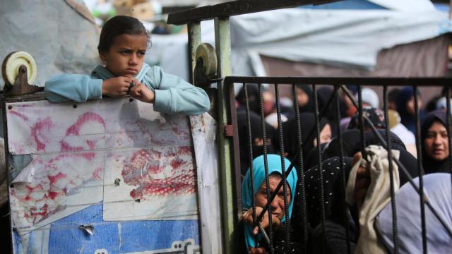 Un grupo de palestinos se reúne en Jan Yunis, al sur de la Franja, para recibir comida.