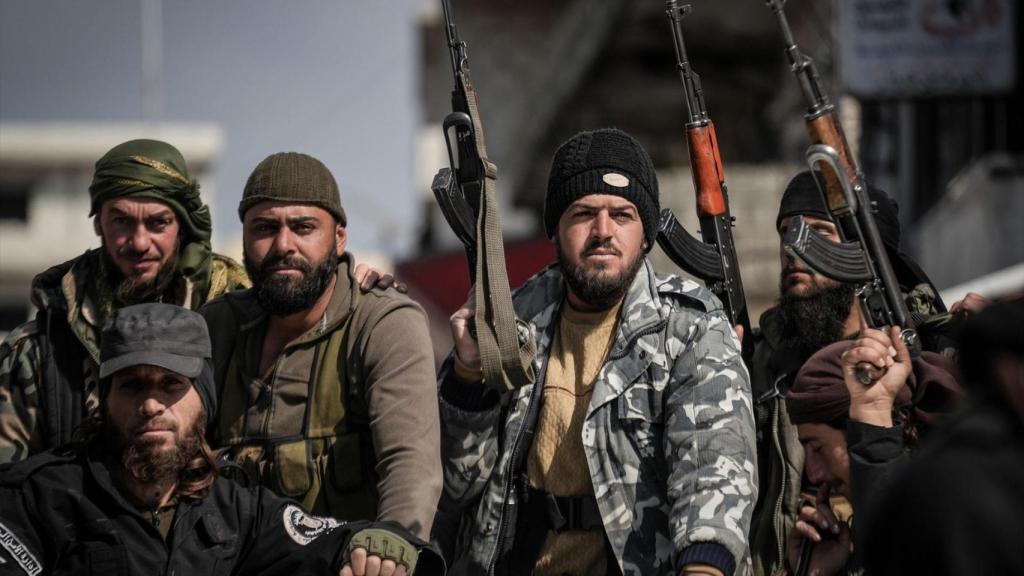 Miembros de las fuerzas de seguridad sirias patrullan una calle en la ciudad de Jableh, al sur de Latakia.