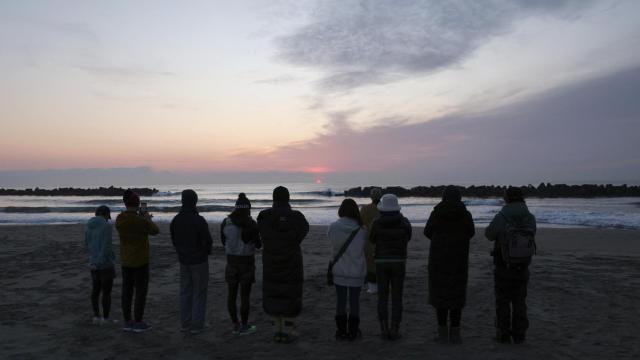 Un grupo de personas reza este martes por las víctimas de Fukushima en la playa de  Arahama en Sendai, en Japón.