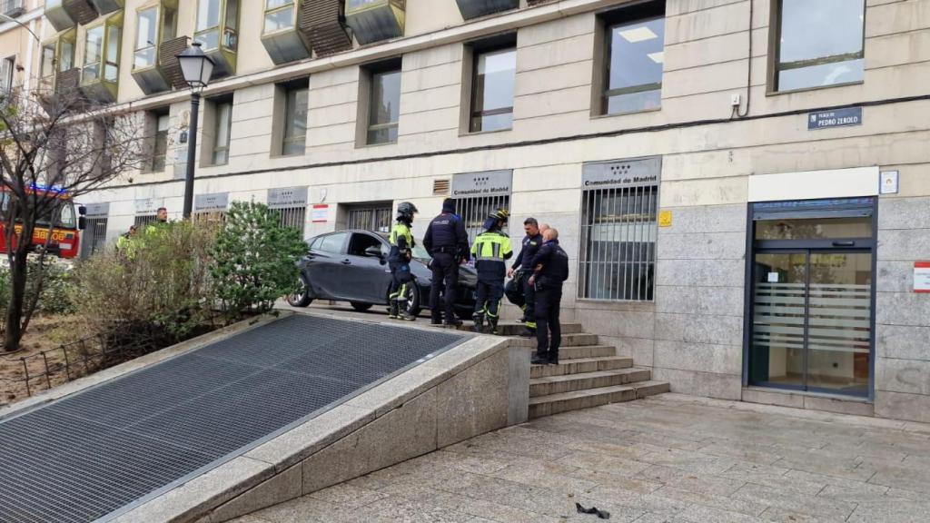 Agentes de la policía y los bomberos de Madrid terminando de 'rescatar' el coche de las escaleras de la Plaza Pedro Zerolo este lunes.