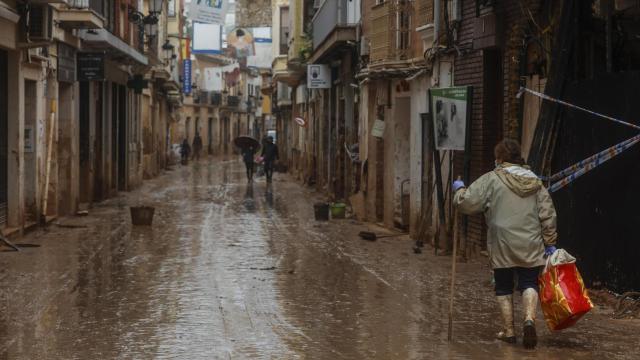 Una mujer pasea por la calle anegada de barro, a 13 de noviembre de 2024, en Paiporta. Europa Press / Rober Solsona