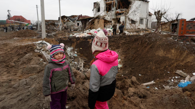 Niños junto a escombros en Kiev, Ucrania, tras un ataque ruso.