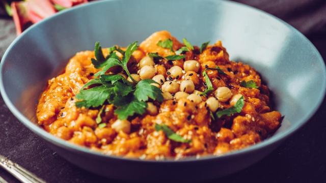 Un plato de garbanzos con tomate.