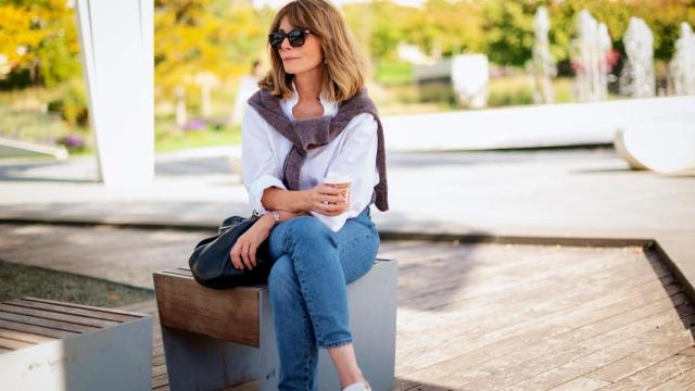 Una mujer con vaqueros y camisa blanca