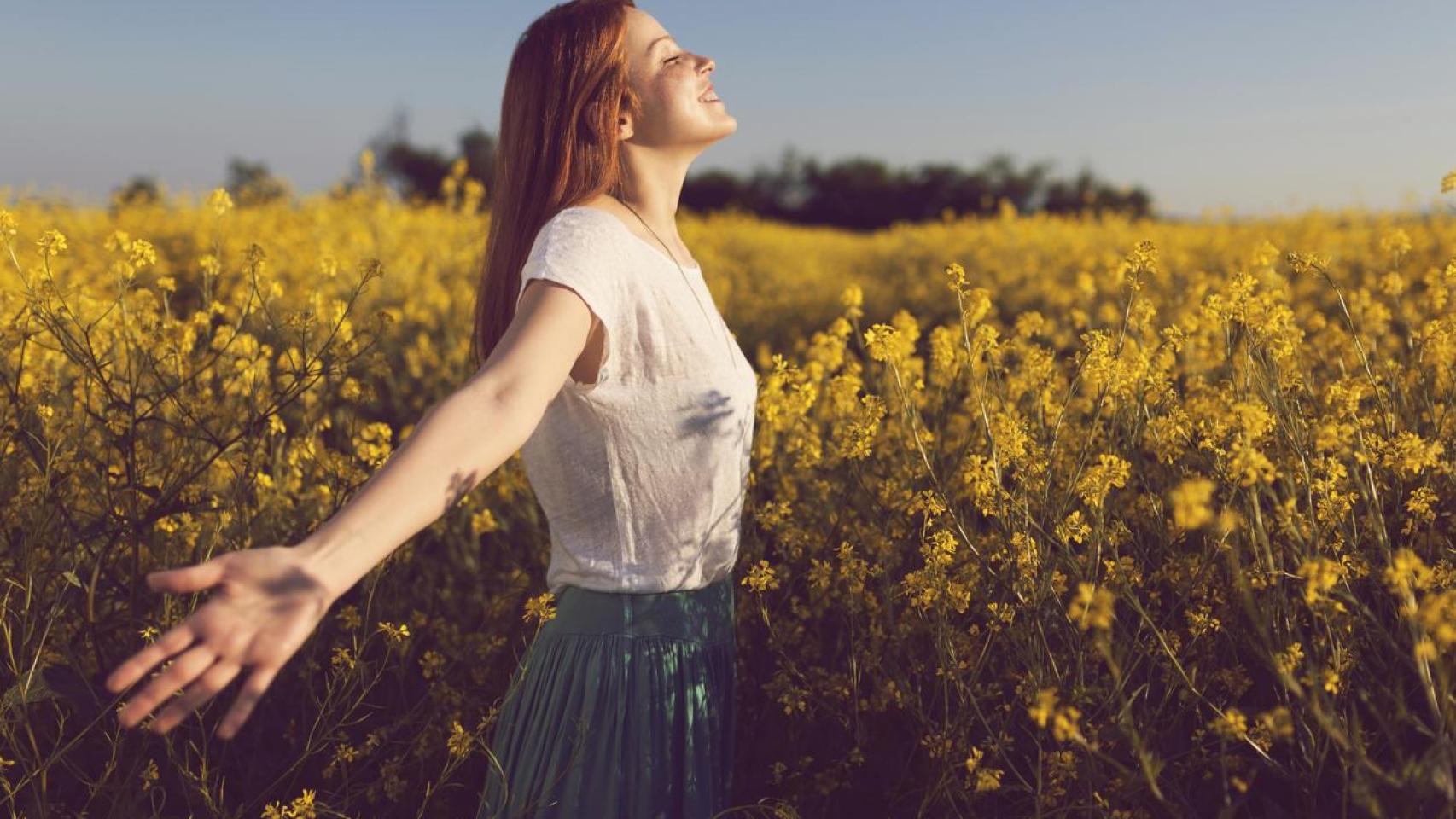 Imagen de archivo de una chica rodeada de flores.