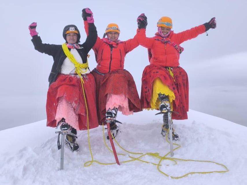 Elena Quispe y sus compañeras cholitas en la cima de una montaña.
