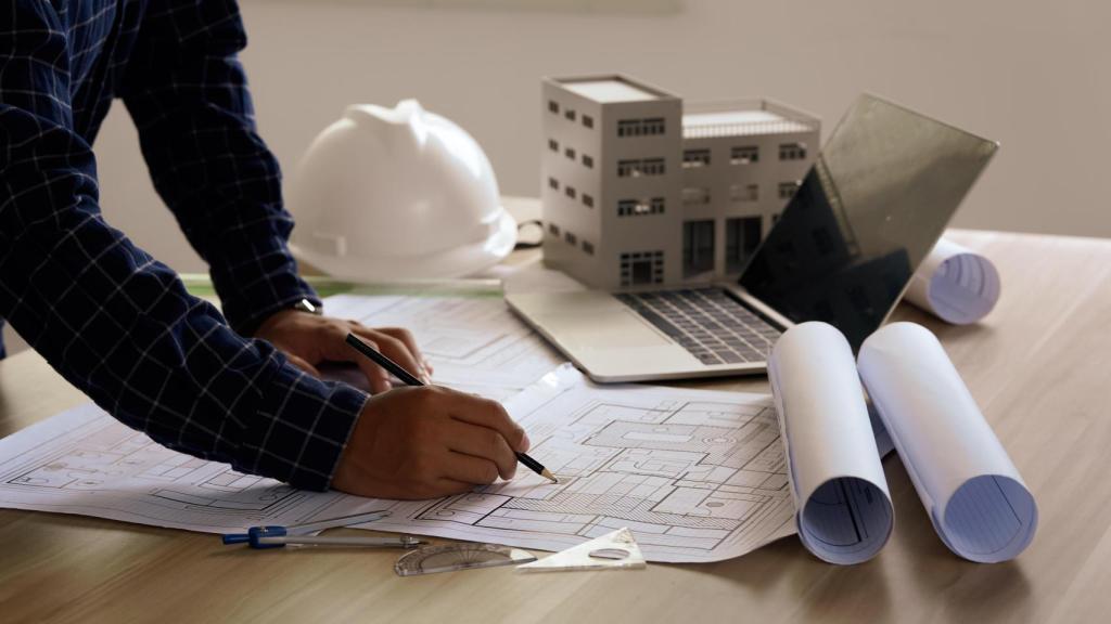 Un profesional trabaja en unos planos arquitectónicos