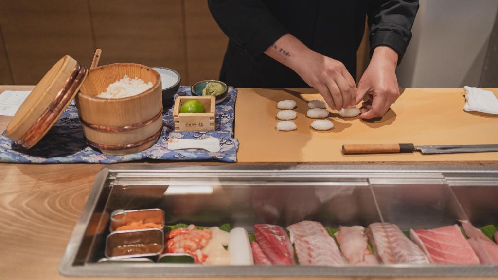 Mario Payán elaborando nigiri en la barra de sushi.