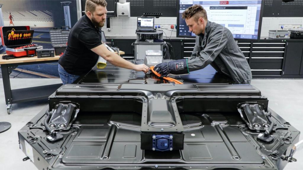 Operarios supervisando la instalación de una batería en un Porsche Taycan