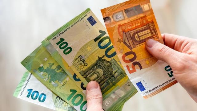 Una persona cuenta billetes manualmente