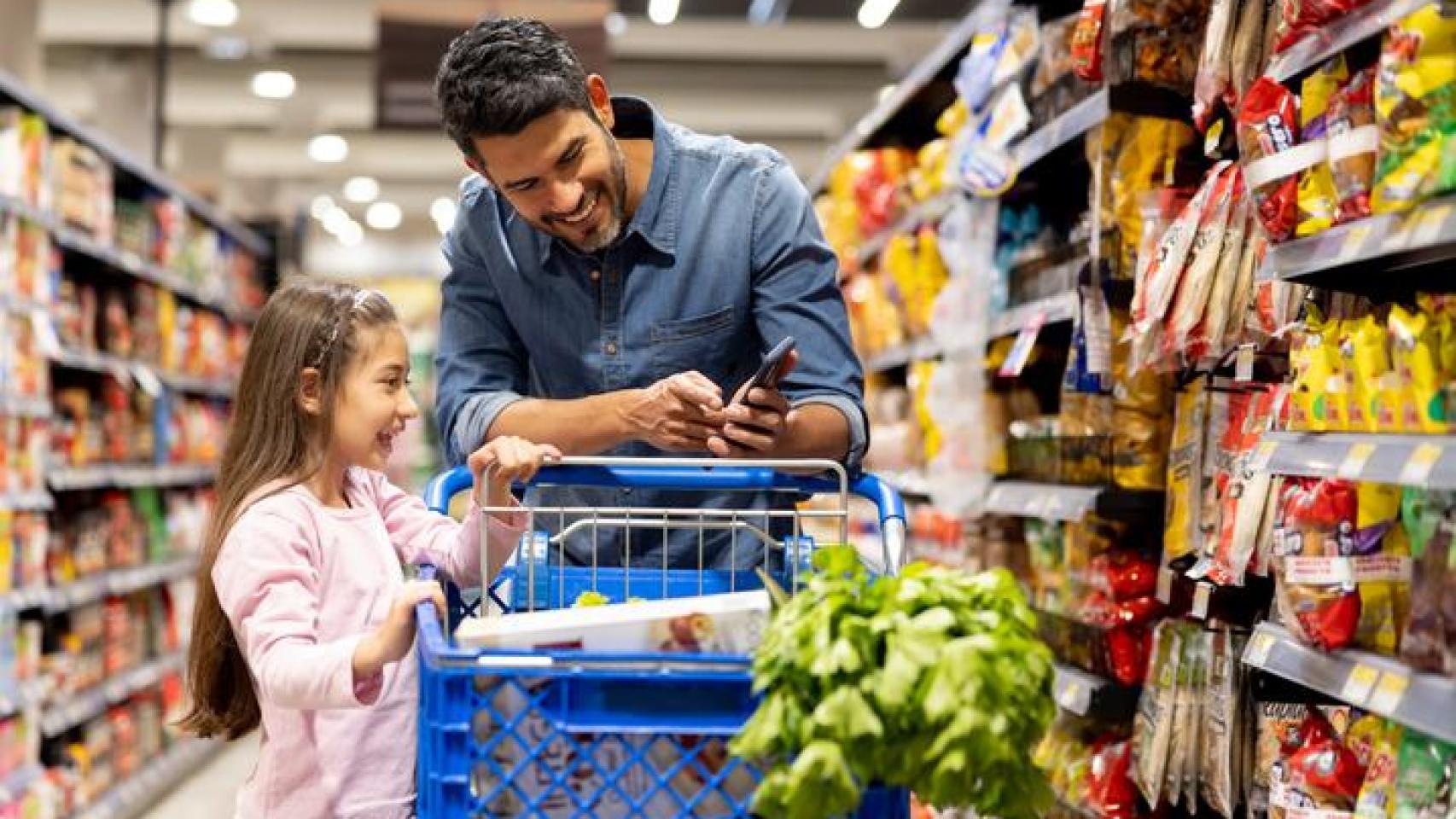 Imagen de archivo de un padre y su hija en el supermercado.