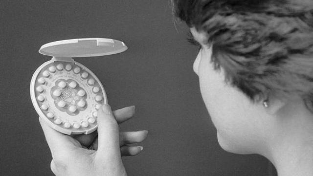 Mujer sosteniendo un pastillero de píldora anticonceptiva que controla el embarazo.