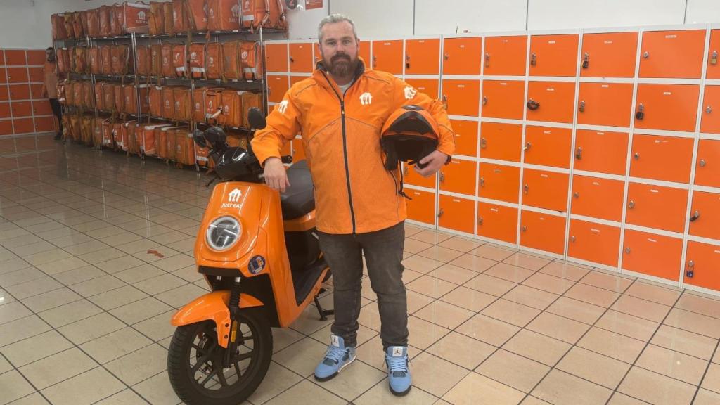 Unai Bratos Hernández, con su moto eléctrica antes de salir a repartir