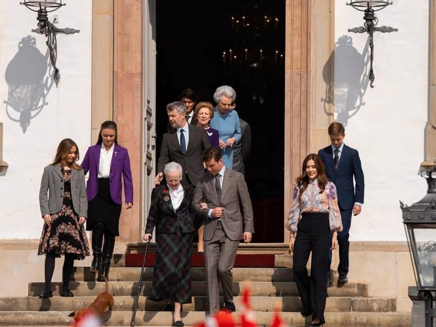 El heredero ayuda a su abuela a bajar las escaleras de palacio.