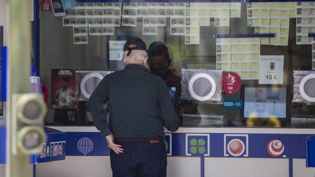 Dos personas compran lotería en una Administración.
