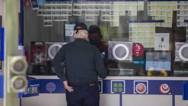 Dos personas compran lotería en una Administración.