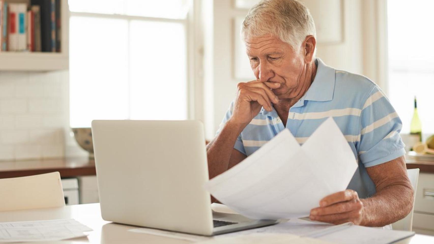 Hombre mayor revisando las facturas de su casa.
