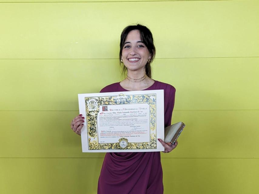 María Martínez sosteniendo el diploma extraordinario del Máster