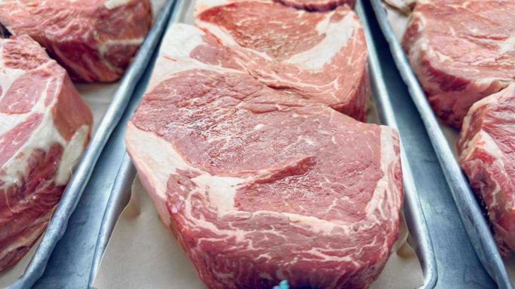Mostrador de carnicería con distintos cortes de carne expuestos.