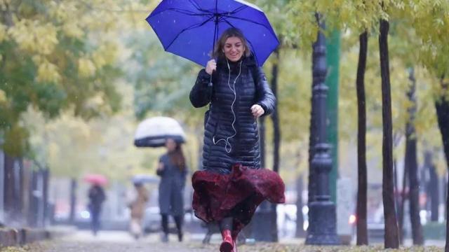 Una mujer camina bajo la lluvia.