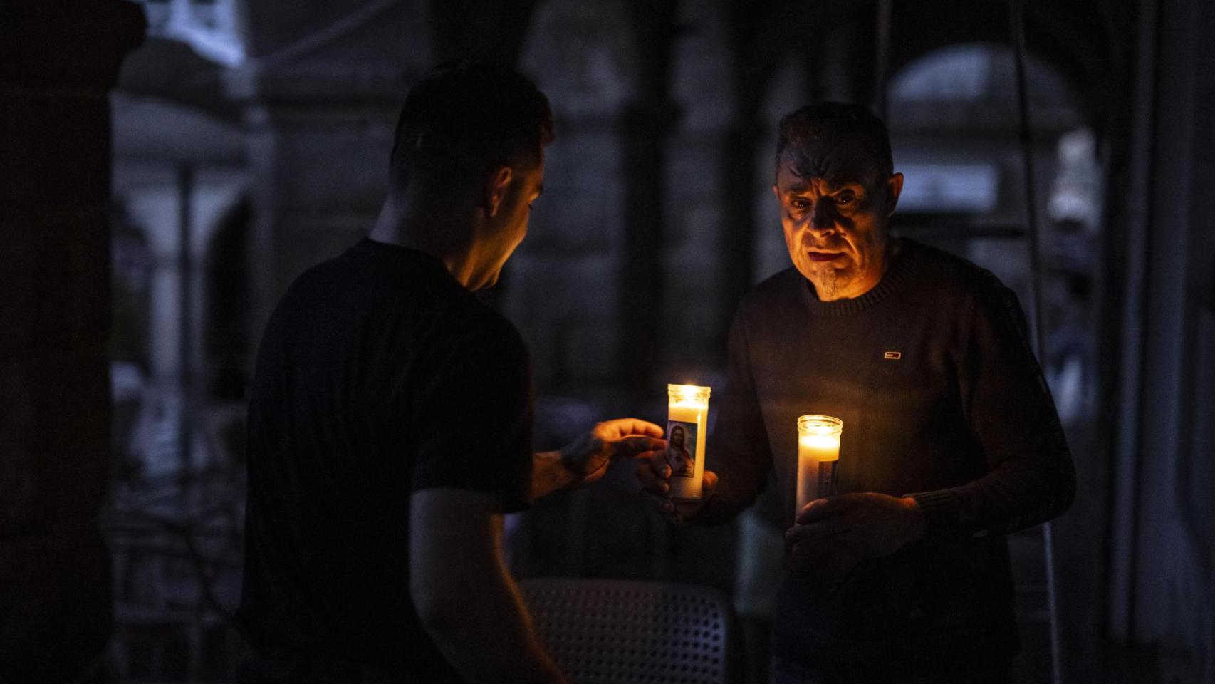Dos personas iluminadas por la luz de las velas al caer la noche durante el apagón eléctrico en Ourense.