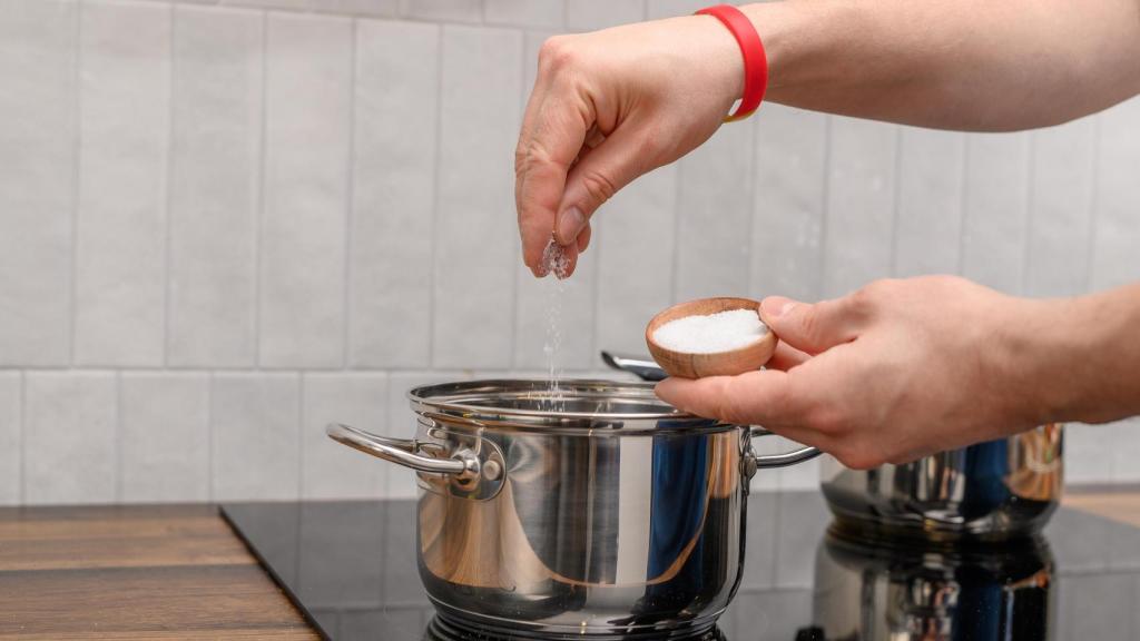 Echando sal en una olla.