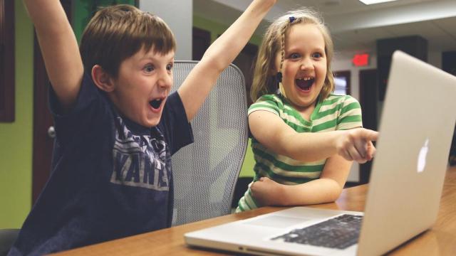 Dos niños se divierten ante un ordenador. Foto: PIXABAY