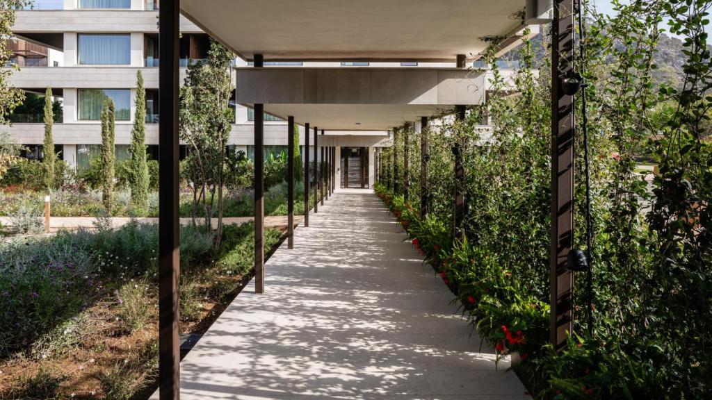 El pasillo hacia las habitaciones, en mitad de un jardín.