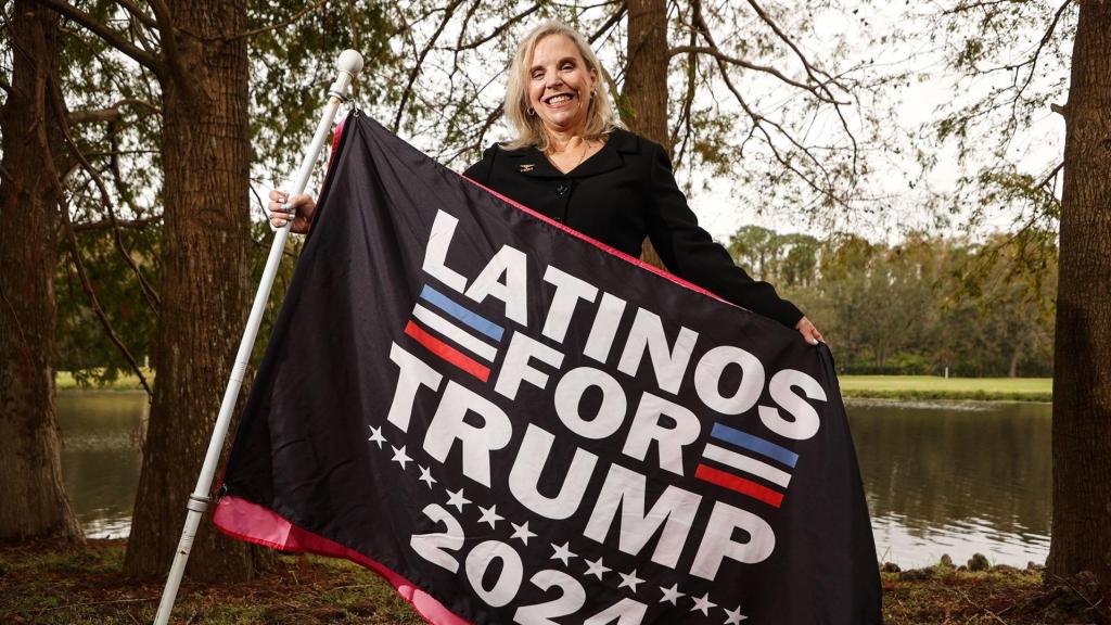 Una mujer posa con una bandera de 'Latinos por Trump' en Tampa, Florida, durante la campaña electoral por la presidencia de Estados Unidos.