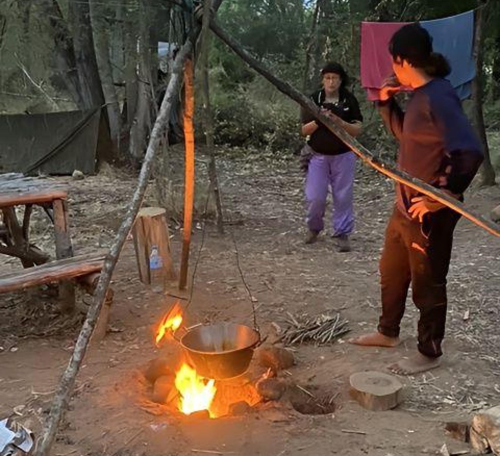 Dos personas preparan la comida en mitad del monte