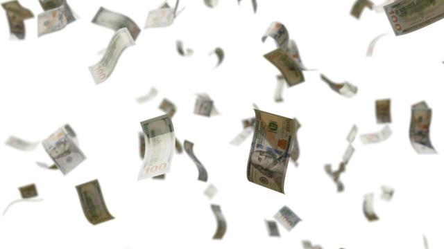 Billetes de dólar vuelan por el aire.