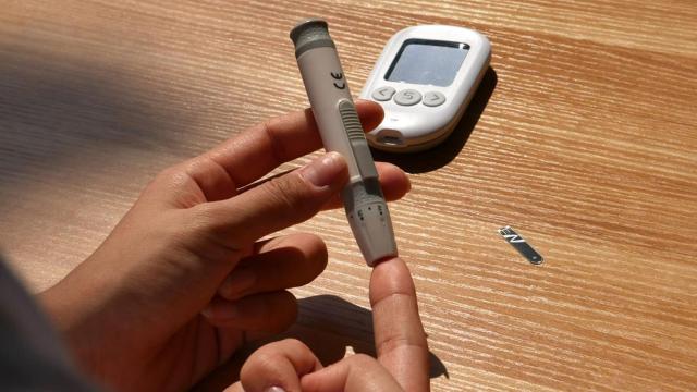 Una persona pinchándose para medir la glucosa.