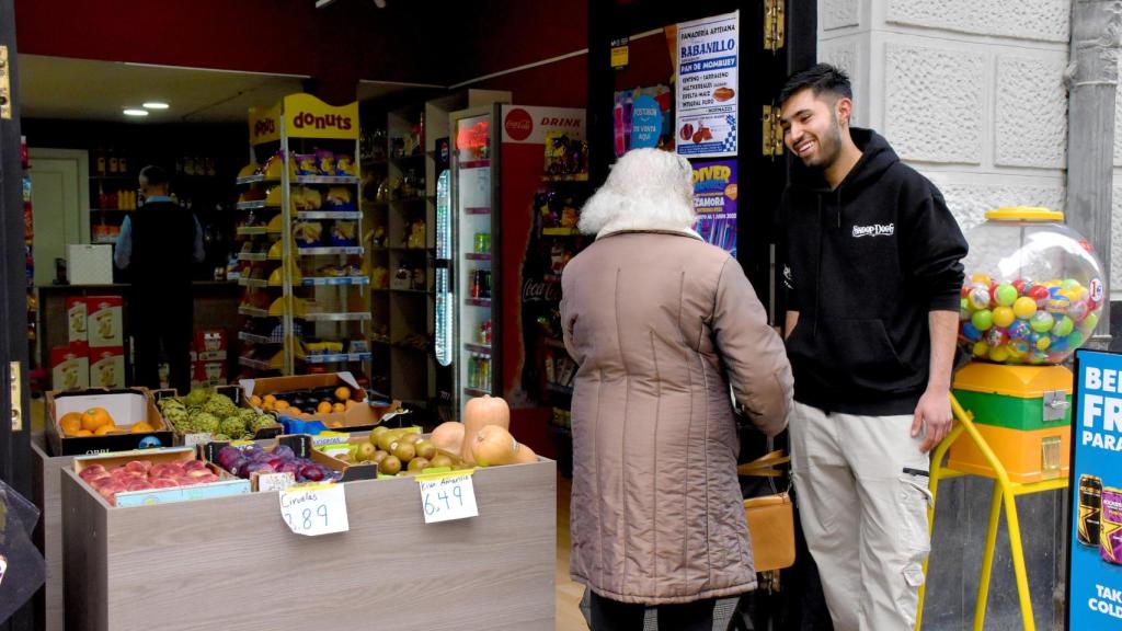 Abdul y su clienta de 96 años charlando en la puerta del establecimiento