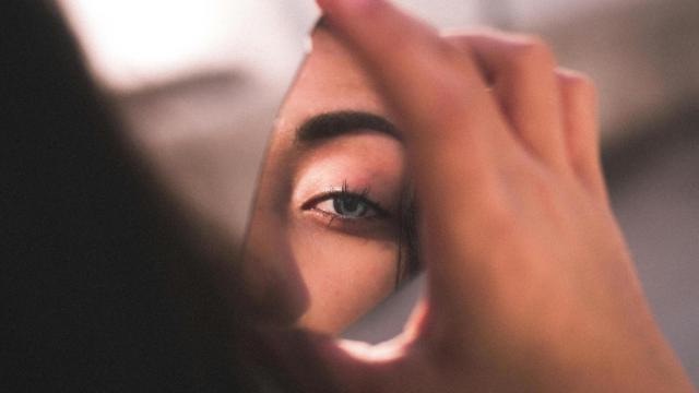 Mujer mirándose en el espejo.