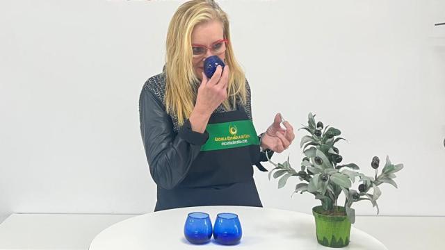 Carmen oliendo un vaso con aceite